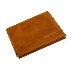 Close-up of brown leather coin pouch with spring closure and decorative stitching