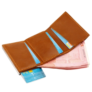 Macro shot of brown leather trifold wallet with manual pop-up card case and cash slot