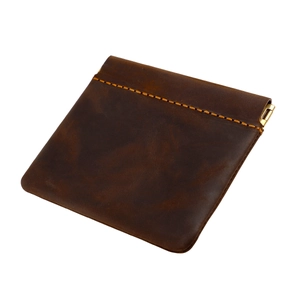 Macro detail of crazy horse leather coin purse with yellow stitching and metal snap closure