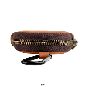 Side view of a vintage round leather coin purse with zipper and metal carabiner clip