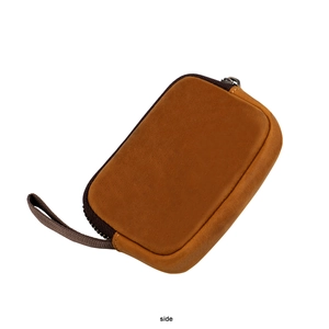 Side view of vintage brown leather coin purse with zipper and sturdy wrist strap
