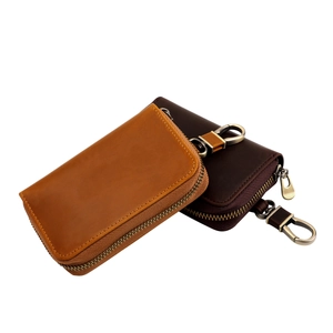 Detail view of vintage crazy horse leather key pouch with brass zipper and metal hook
