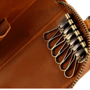 Detail view of brown genuine leather key case with six brass hooks and smooth zipper