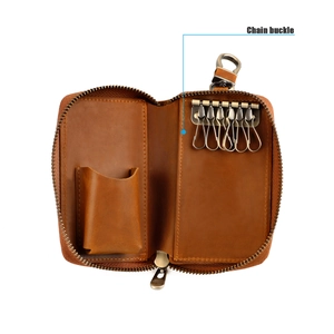 Detail view of the interior showing six metal key hooks and a leather pocket in a brown pouch