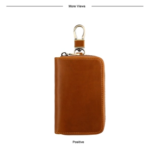Detail of vintage brown leather car key case with bronze zipper and metal swivel hook