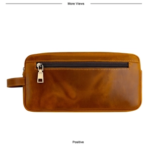 Detail van vintage bruine crazy horse lederen tas met rits aan de voorkant en handvat