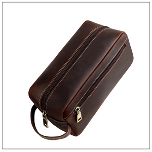 Detailopname van donkerbruine vintage toilettas van leer met dubbele ritssluiting