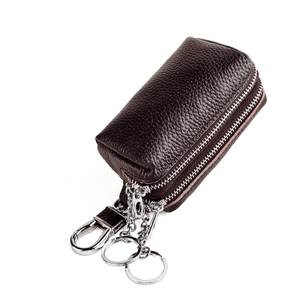 Detailed view of dark brown pebbled leather key case with double zippers and metal carabiner