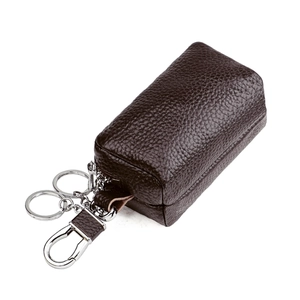 Detail of dark brown pebble grain leather key case with silver metal hook and dual rings