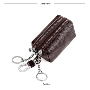 Detail of genuine brown leather car key pouch featuring double zippers and silver metal rings