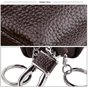 Detail view of dark brown litchi leather texture with silver metal hooks and key rings