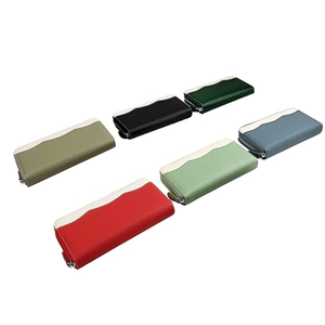 Detail view of colorful long leather zip wallets with contrast wavy top and pebble texture