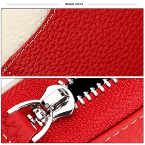 Macro shot of red pebble grain leather texture with white stitching and silver zipper detail