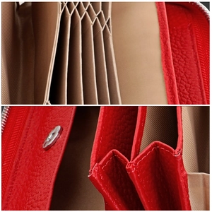 Macro detail of red pebbled leather wallet showing accordion card slots and metal snap