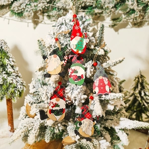 Handcrafted wooden Christmas gnome ornaments hanging on a snowy tree for festive holiday decor