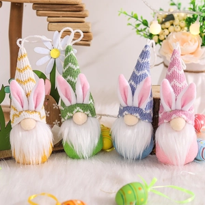 Set de cuatro gnomos de Pascua coloridos con orejas de conejo en alfombra blanca