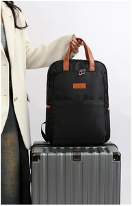 Business laptop backpack on a silver suitcase with leather handles for travel
