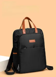 Macro shot of black nylon backpack details with premium brown leather handle and zipper