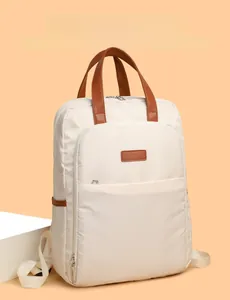 Detail of minimalist beige nylon backpack with premium brown leather handles and zipper pocket