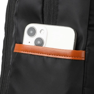 Detail of the high-density nylon side pocket with leather trim holding a white smartphone