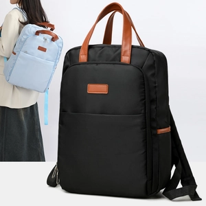Detail of waterproof nylon backpack with leather handles and large front zipper pocket