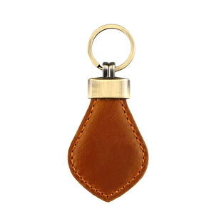 Macro shot of vintage dark brown crazy horse leather keychain with orange hand stitching