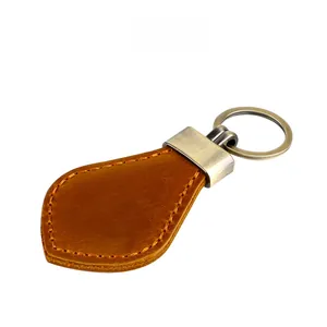 Macro detail of vintage caramel crazy horse leather keychain with brushed metal ring