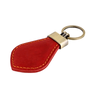 Detailed view of red Crazy Horse leather car keychain with vintage bronze ring and stitching