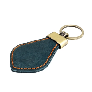 Detail of vintage teardrop leather keychain with orange stitching and bronze hardware