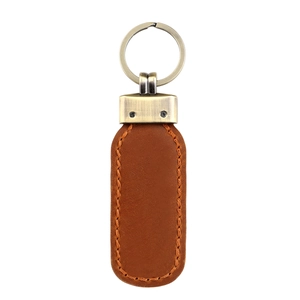 Close-up of vintage brown leather keychain with orange stitching and bronze hardware