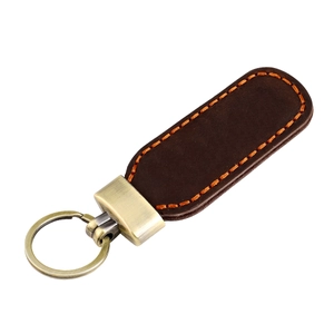 Detail of vintage brown crazy horse leather keychain with orange stitching and bronze ring