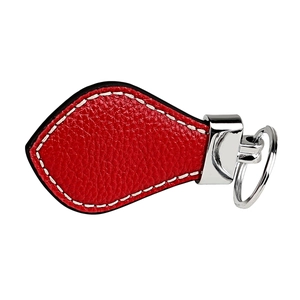 Macro detail of red lychee grain leather keychain with silver metal ring and white stitching