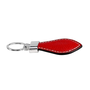 Detail of red textured leather heart keychain with white stitching and silver ring