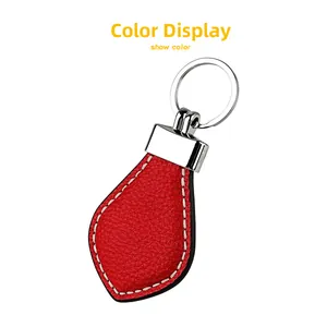 Close-up of red lychee grain leather keychain with white stitching and silver metal ring