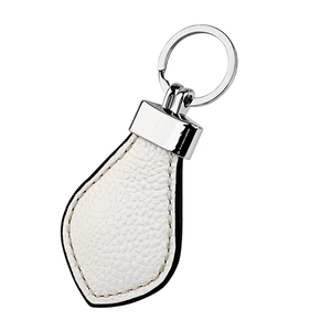 Close-up of white lychee leather car keychain with silver metal ring and beige stitching