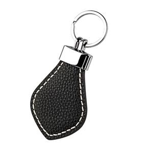 Detail of black leather teardrop keychain with white contrast stitching and silver metal ring