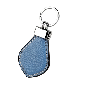 Detail of blue pebble grain leather keychain with silver metal ring and white stitching