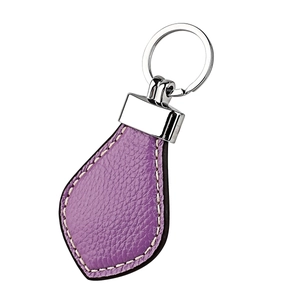 Macro shot of purple lychee grain leather keychain with white stitching and silver ring