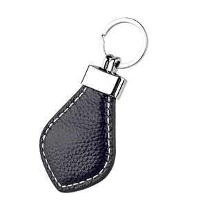 Macro detail of genuine leather car keychain with litchi texture and silver metal ring
