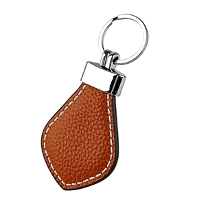 Detailed view of brown litchi pattern cowhide leather keychain with white stitching