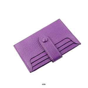 Macro shot of purple lychee grain leather card holder with button strap and card slots