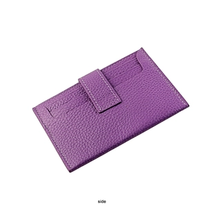 Detail view of purple lychee grain leather card holder with secure strap and white stitching