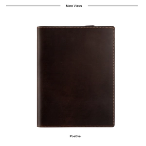 Detail of dark brown leather notebook cover featuring precise orange stitching and pen loop