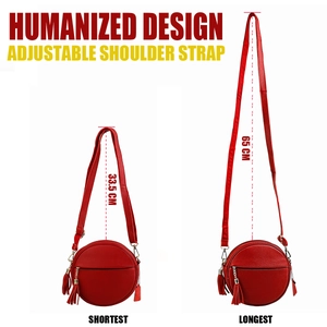 Detail of adjustable shoulder strap on red leather round crossbody bag with tassel