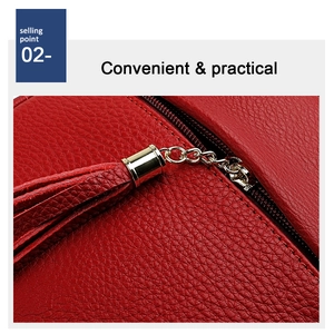 Detail of red lychee grain leather crossbody bag with gold metal ring and leather tassel