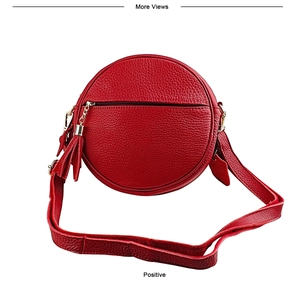 Detailed front view of a red round leather crossbody bag featuring gold chain tassels