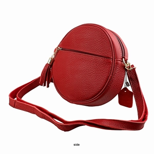 Detail of red circular leather crossbody bag showing lychee texture and tassel zipper pull