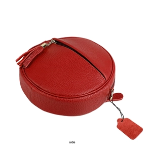 Detail view of red pebble grain leather round bag with matching tassel and side view