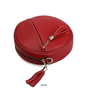 Macro detail of red litchi grain leather round bag with dual tassels and gold zipper