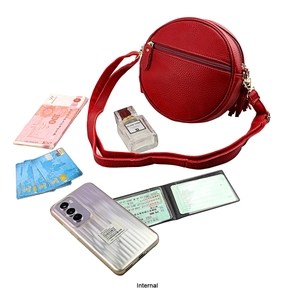 Internal view of a red round leather crossbody bag with items showing its storage capacity